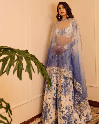 MINDBLOWING FLORAL WHITE LEHENGA CHOLI WITH BLUE FLOWERS